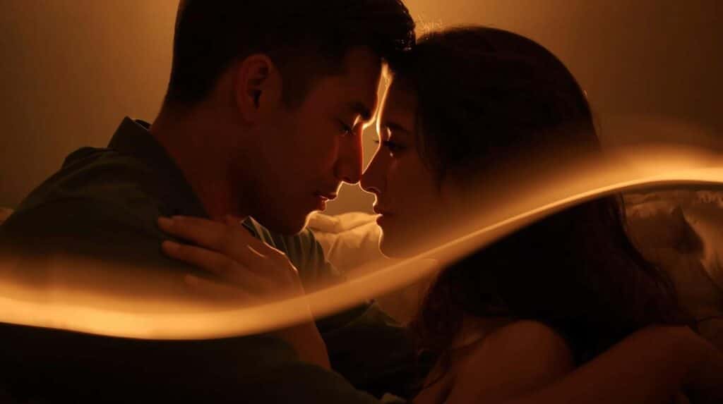 A close-up, warm image of a couple sitting together on a couch. They are not speaking, but are looking into each other's eyes. Above them, a faint, glowing line or a series of dots connects their foreheads, as if their thoughts or emotions are flowing between them. Their faces are calm and their body language is open and relaxed, showing a sense of deep, quiet understanding.